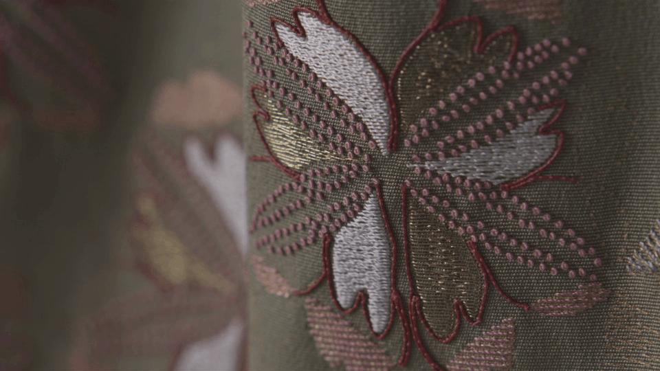 2003年作　繍箔訪問着「風趣文」平成15年第50回日本伝統工芸展出品作品。それぞれ四季を表す4つの文様を、風の流れが交差するように配した作品。左肩から流れる文様は、夏を表す「水」の漢字のフォルムから着想を得て、製作途中に瑞々しさをさらに進化させたもの。